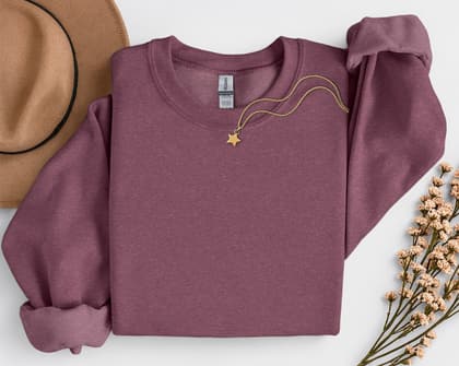 Gildan 18000 Sweatshirt — Folded with Props mockup in Heather Sport Dark Maroon