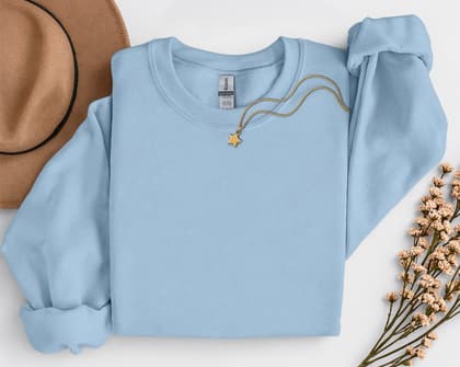 Gildan 18000 Sweatshirt — Folded with Props mockup in Light Blue