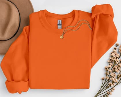 Gildan 18000 Sweatshirt — Folded with Props mockup in Orange